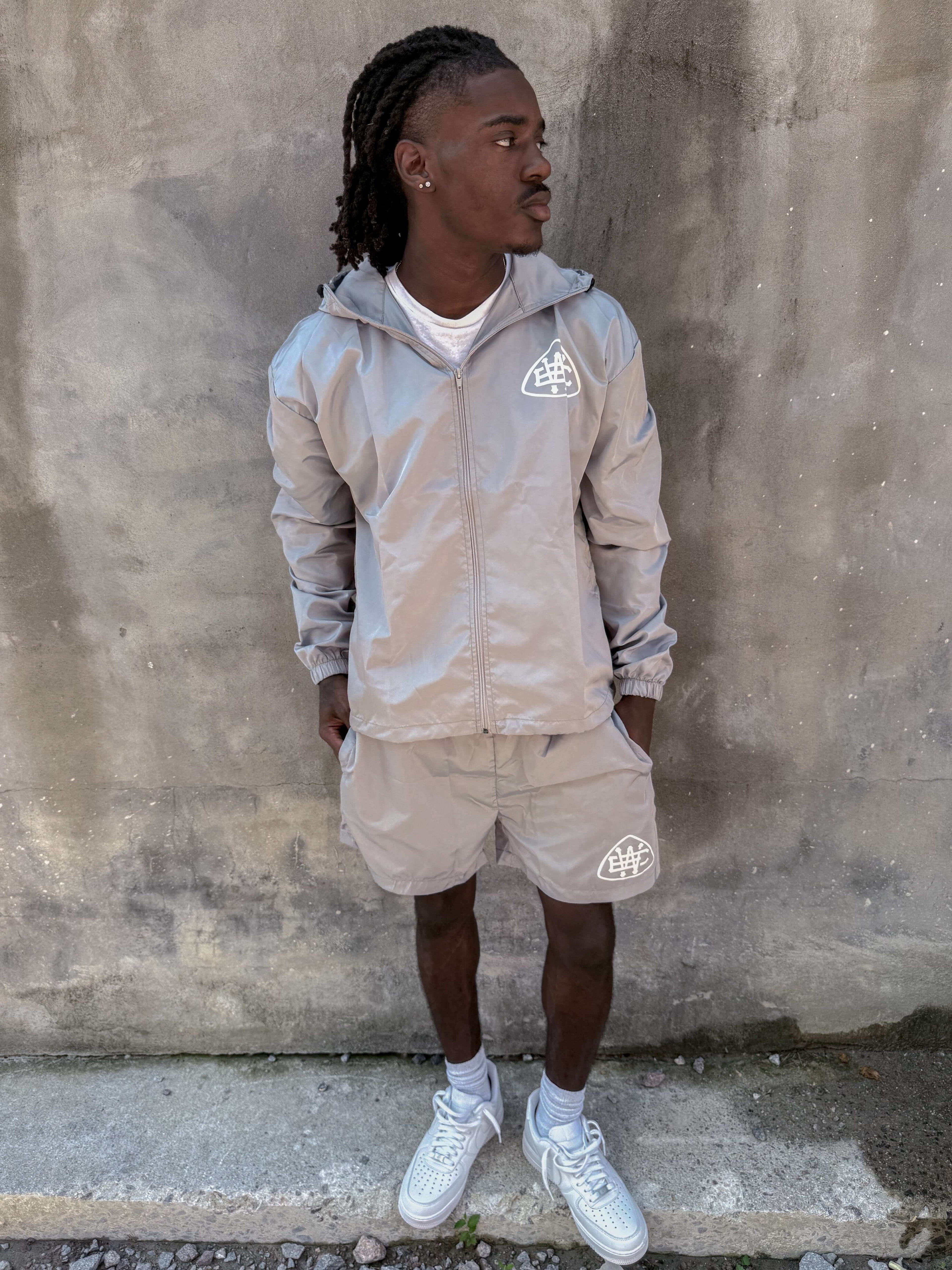 Casual grey unerring set featuring drawstring hood, elastic cuffs, and bold logo, perfect for everyday wear.