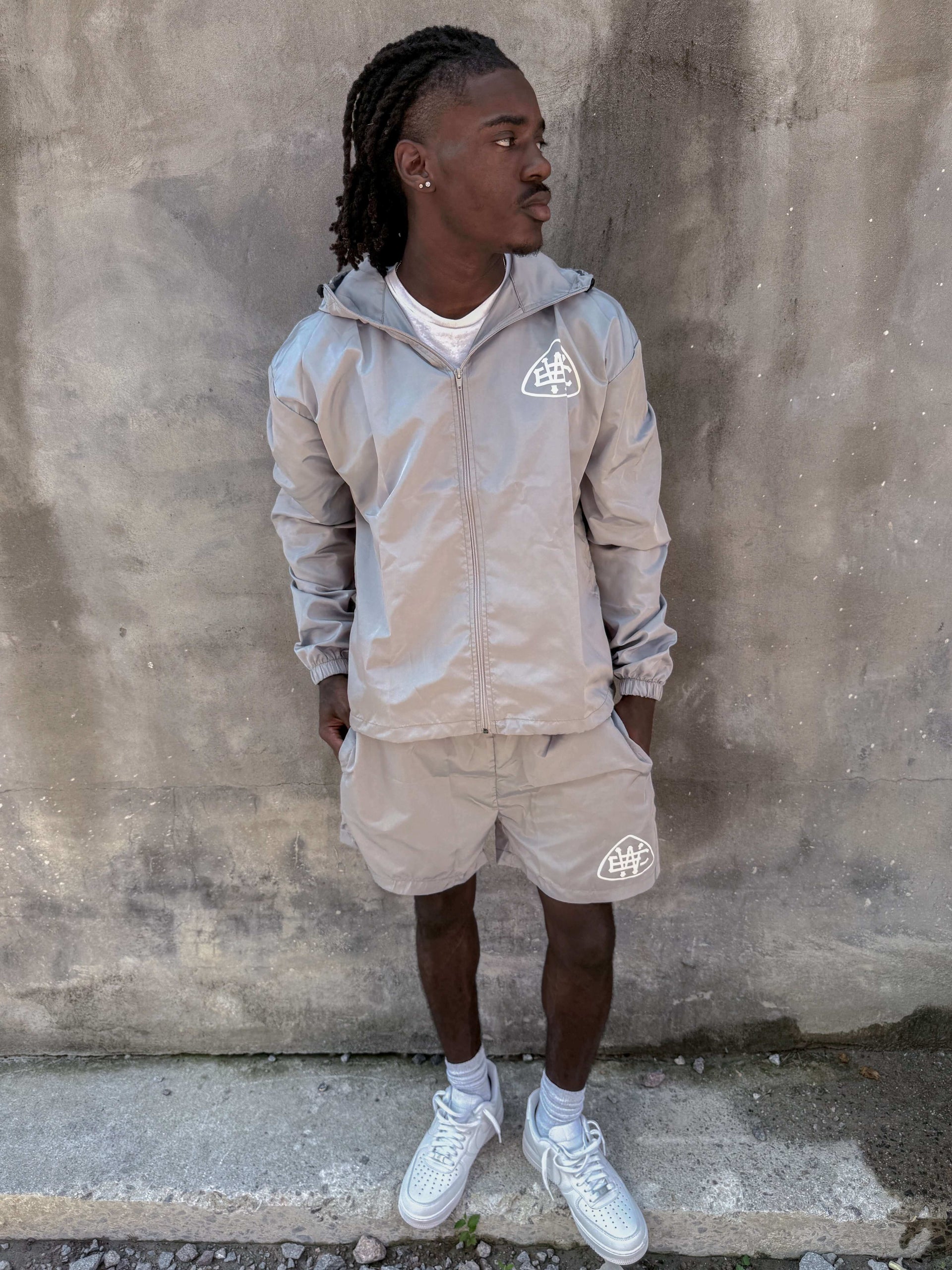 Casual grey unerring set featuring drawstring hood, elastic cuffs, and bold logo, perfect for everyday wear.